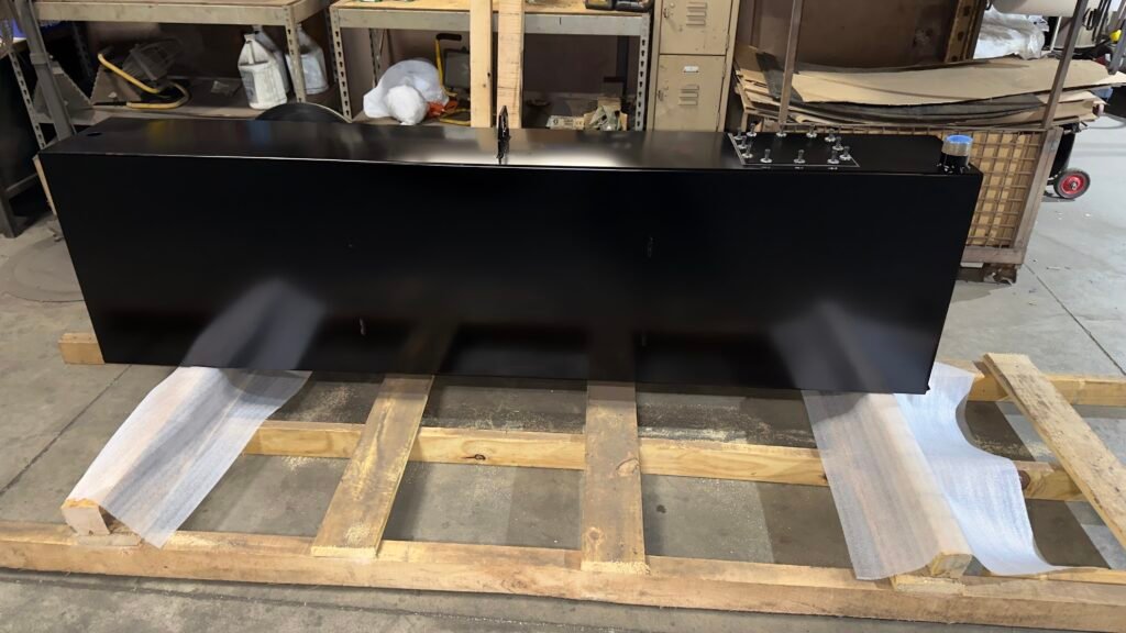 Long custom hydraulic reservoir tank with black powder coat finish