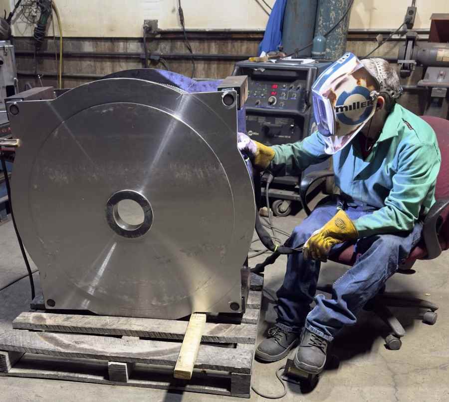 Welder fabricating large steel weldment in Iowa fabrication shop – Engineered Welding